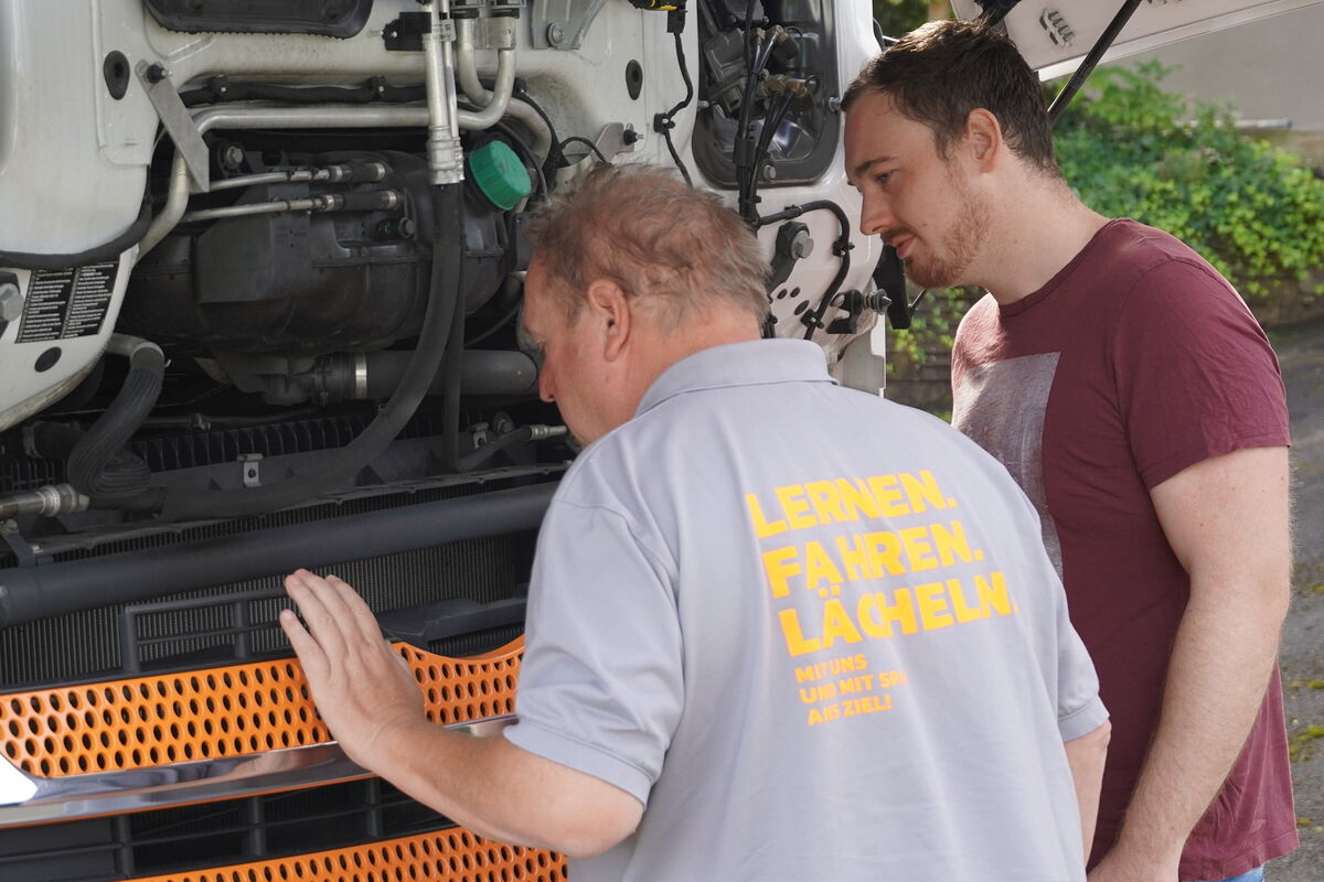 LKW Fahrlehrer mit Fahrschüler vor dem LKW